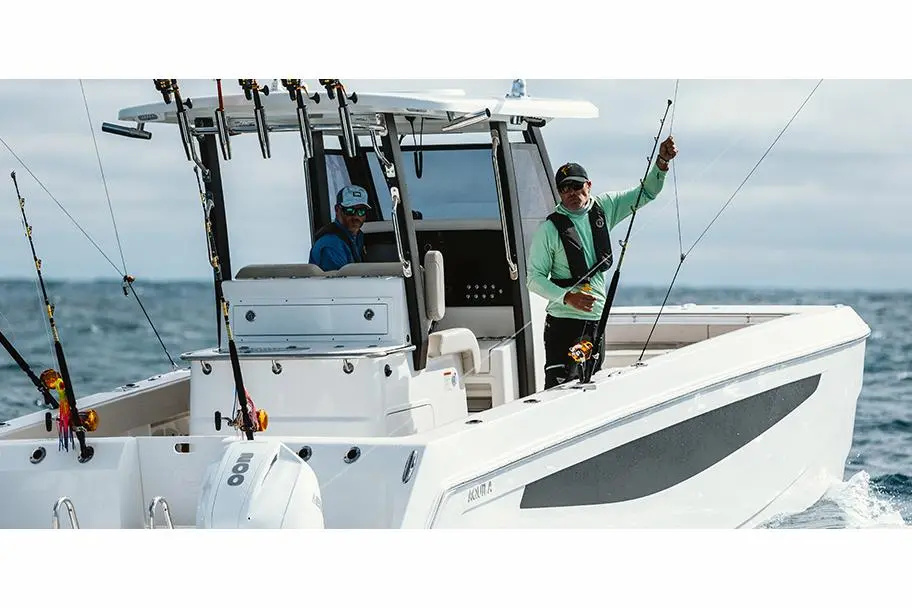 Two fishermen on a white boat, one casting a fishing rod and the other sitting inside, with fishing gear visibly mounted.